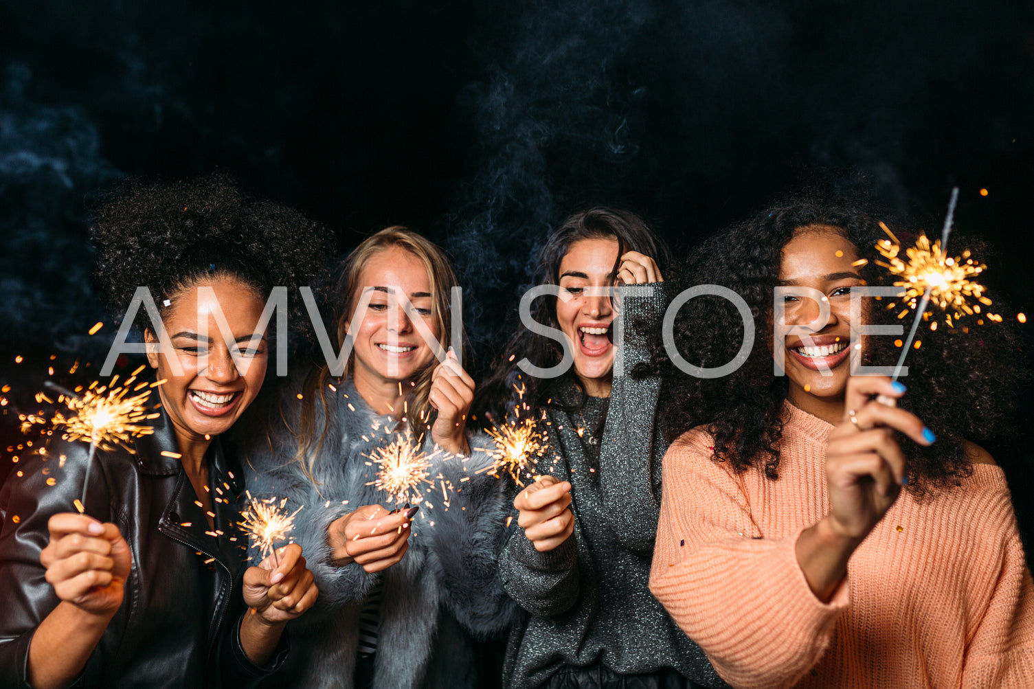 Group of young female friends having fun, raised hands up with sparklers	