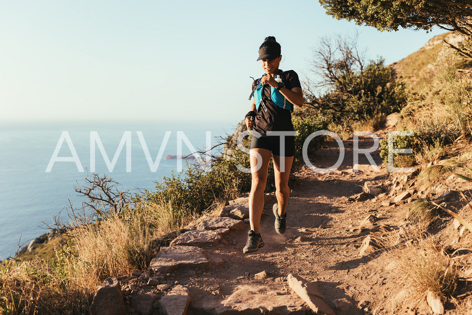 Fit woman running on the mountain trail. Female athlete in sportswear practicing cross country running.