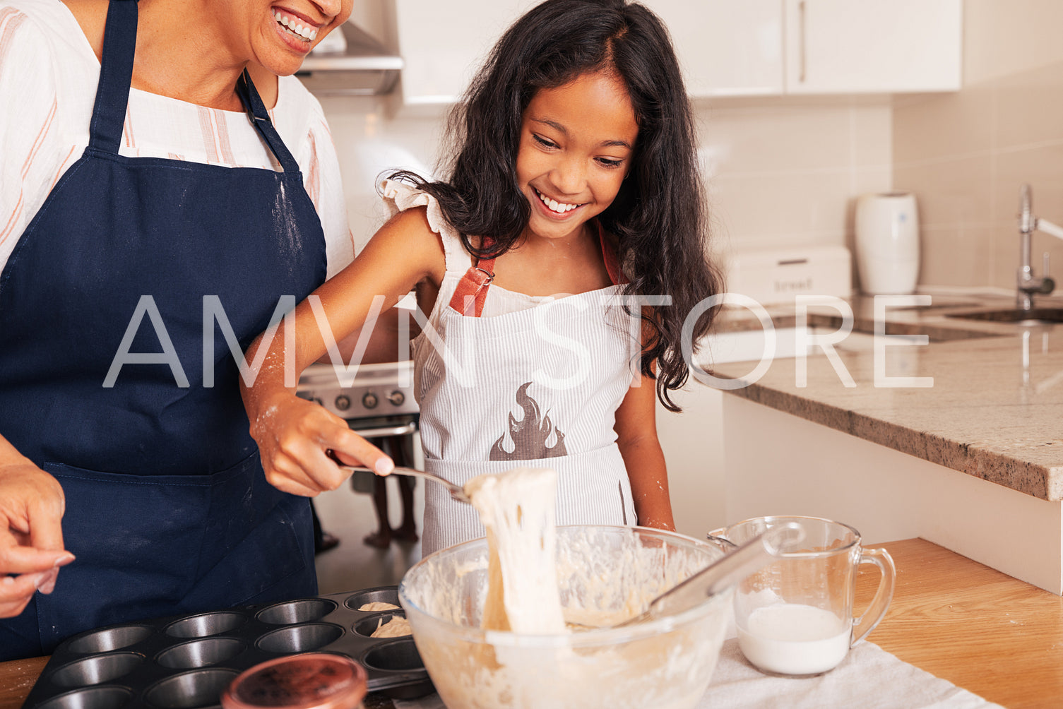 Smiling girl scoops batter from a bowl