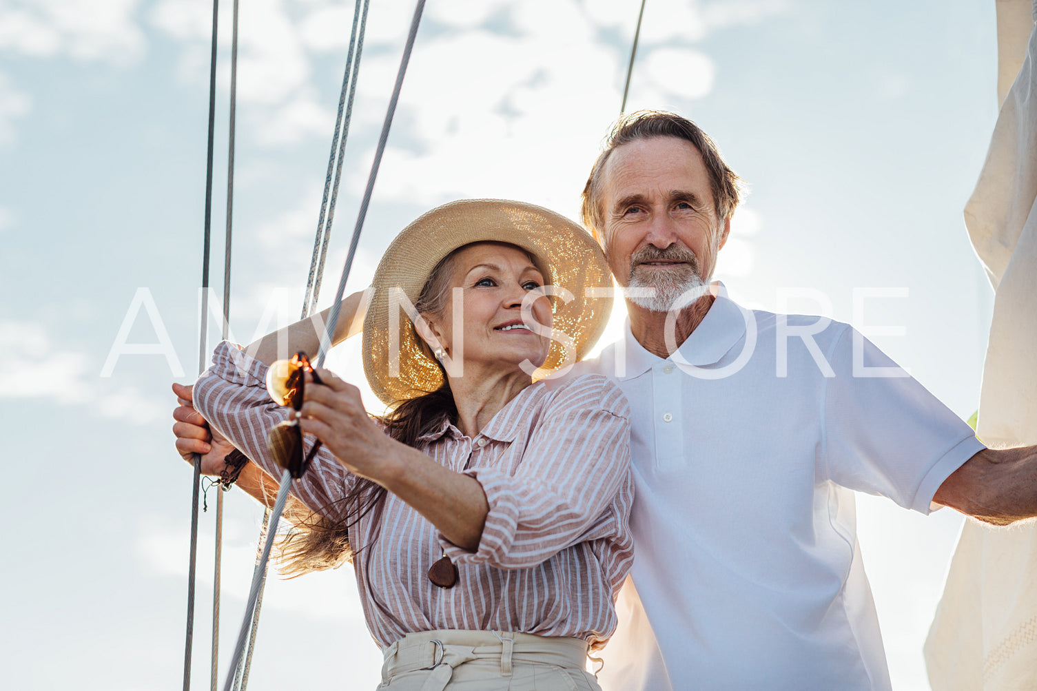 Mature couple standing on a yacht. Two stylish senior people embracing on a sailboat.	