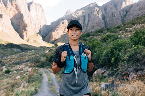 Woman in sportswear walking on abandoned road in valley