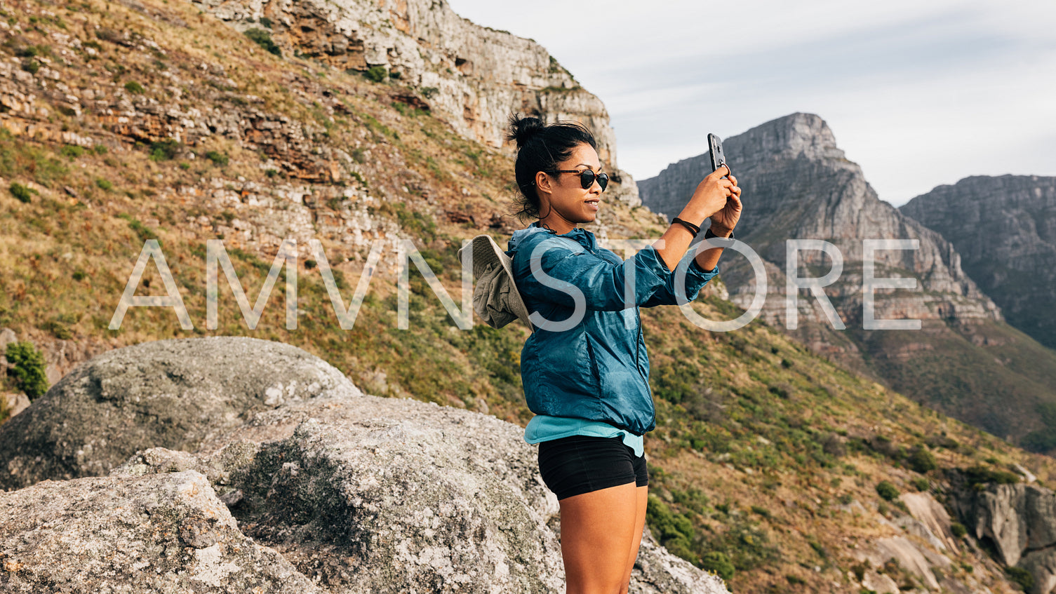 Tourist woman doing nature photography on a smartphone. Female hiker shoots video for social media.