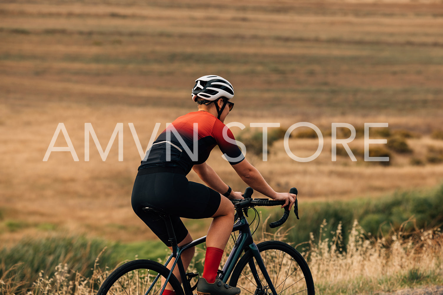 Back view of female cyclist on a country road training for competition