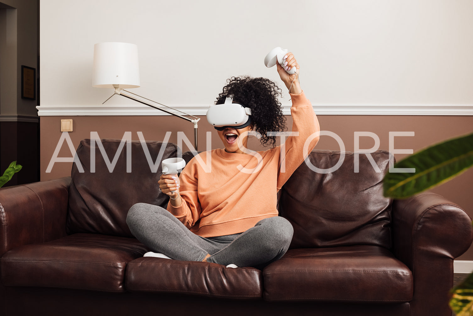 Excited female gamer using virtual reality headset while sitting