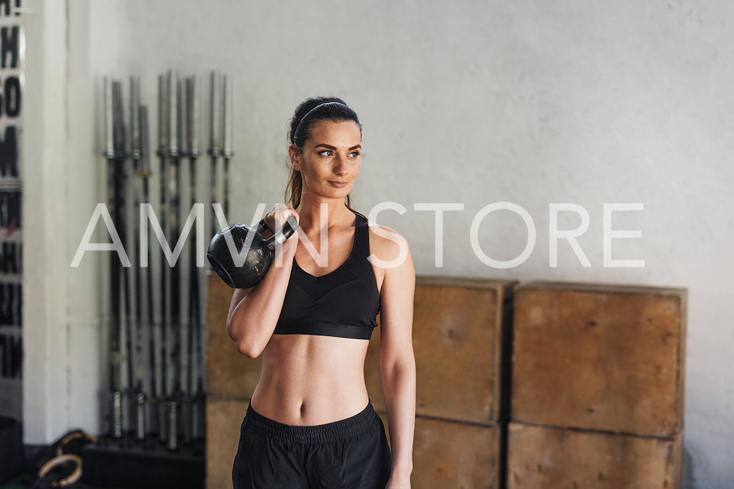 Young athlete in sportswear doing workout with kettlebell in sport club	