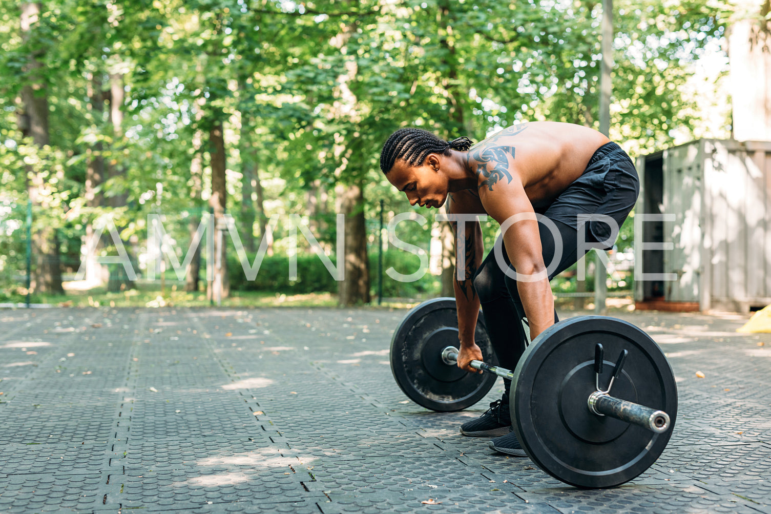 Side view of bare-chest athlete with a barbell. Sportsman preparing for deadlifting.	