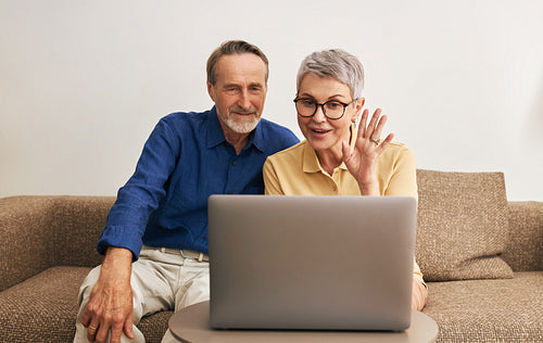 Senior couple using laptop computer for online conversation