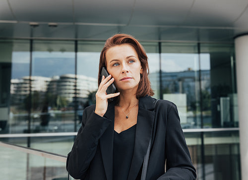 Portrait of a middle-aged female with ginger hair making a phone call