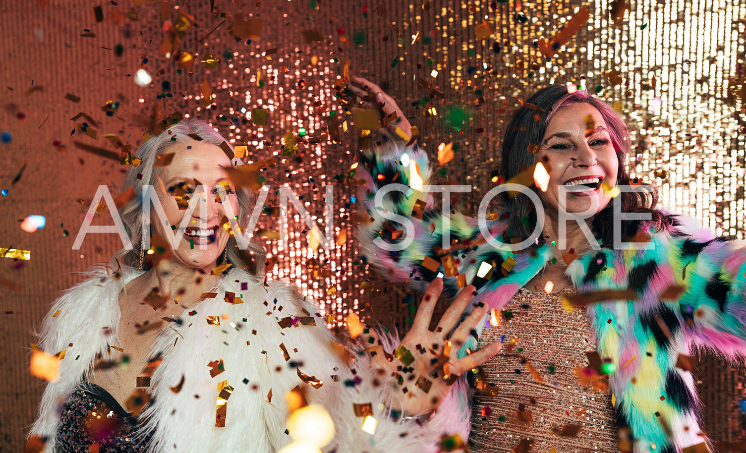 Senior females in fur coats celebrating together in studio under