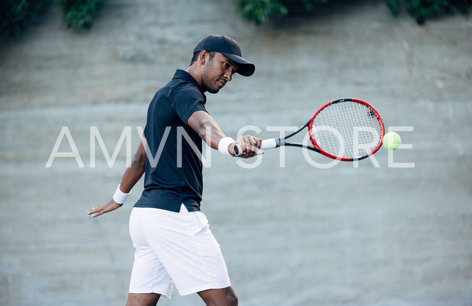 Young tennis player in cap hitting the ball during match outdoors