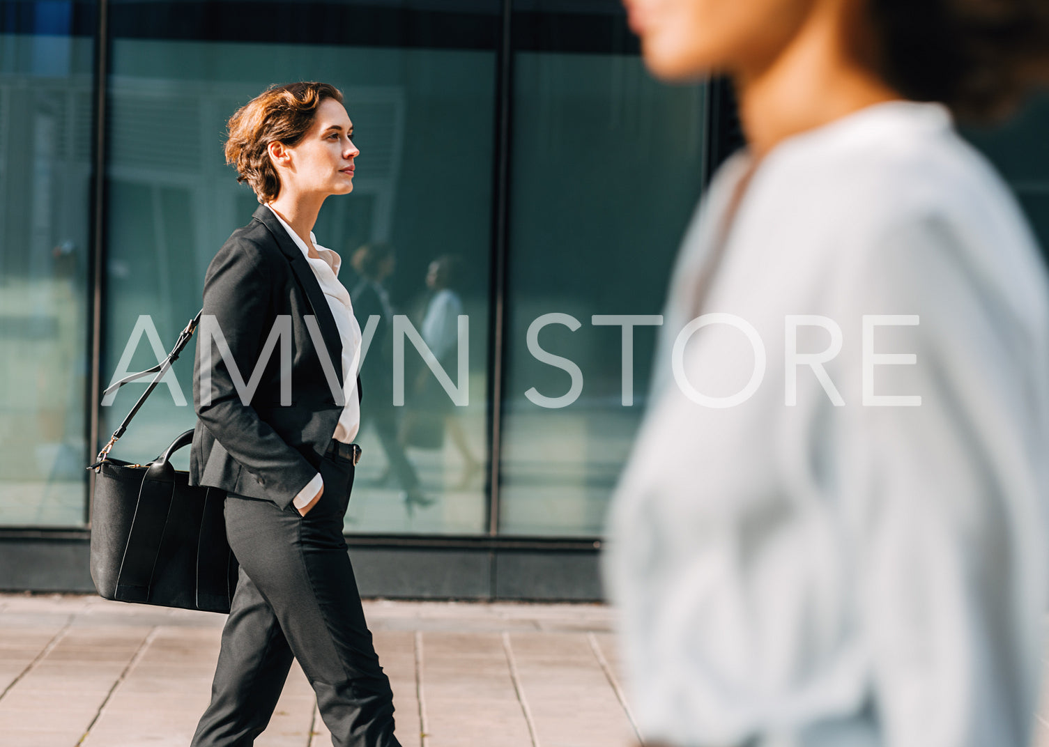 Businesswoman commuting to the office carrying her bag. Woman in formalwear walking outdoors.	