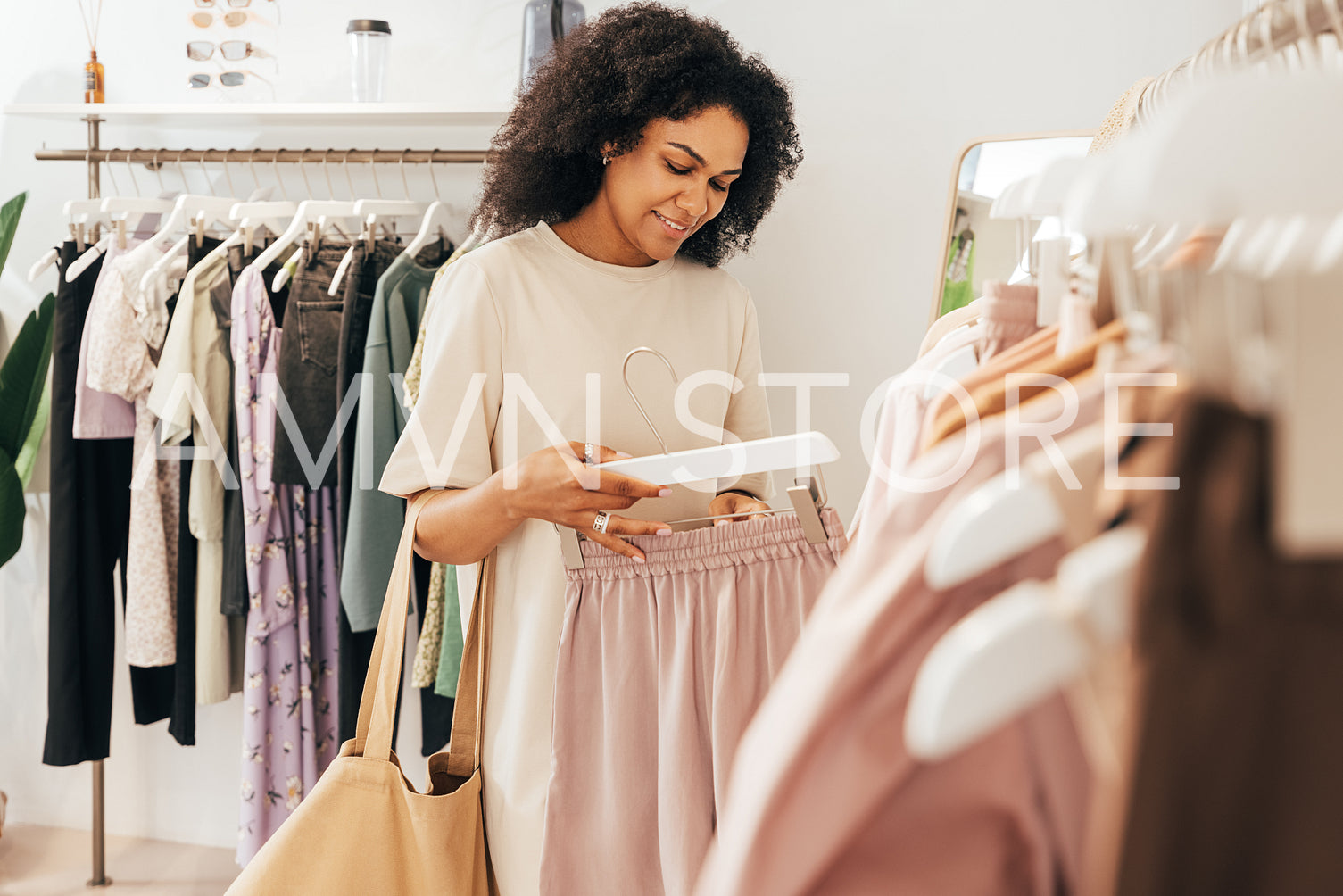 Woman looking at a quality of shorts in a clothing store. Shopper buying clothes in a boutique.