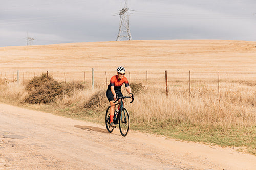 Woman in sportswear on road bike exercising on countryside road