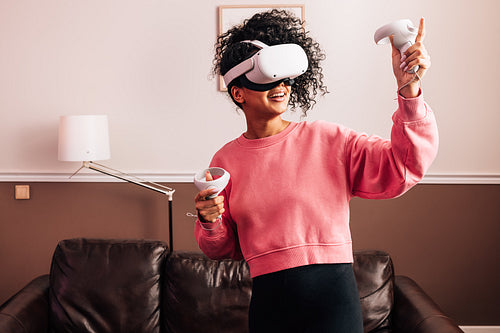 Young woman having fun with VR set. Smiling female using a virtual reality headset.