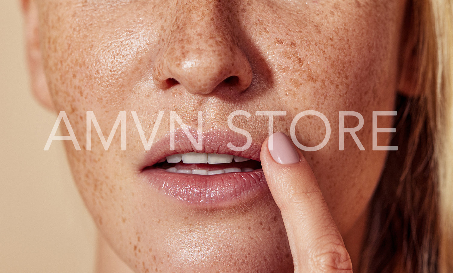 Close-up of unrecognizable woman with freckled skin touching lips with finger