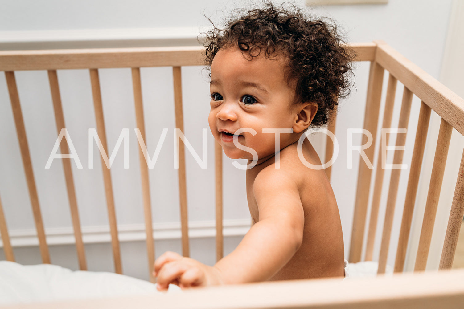 Portrait of cute baby boy standing in crib at home	