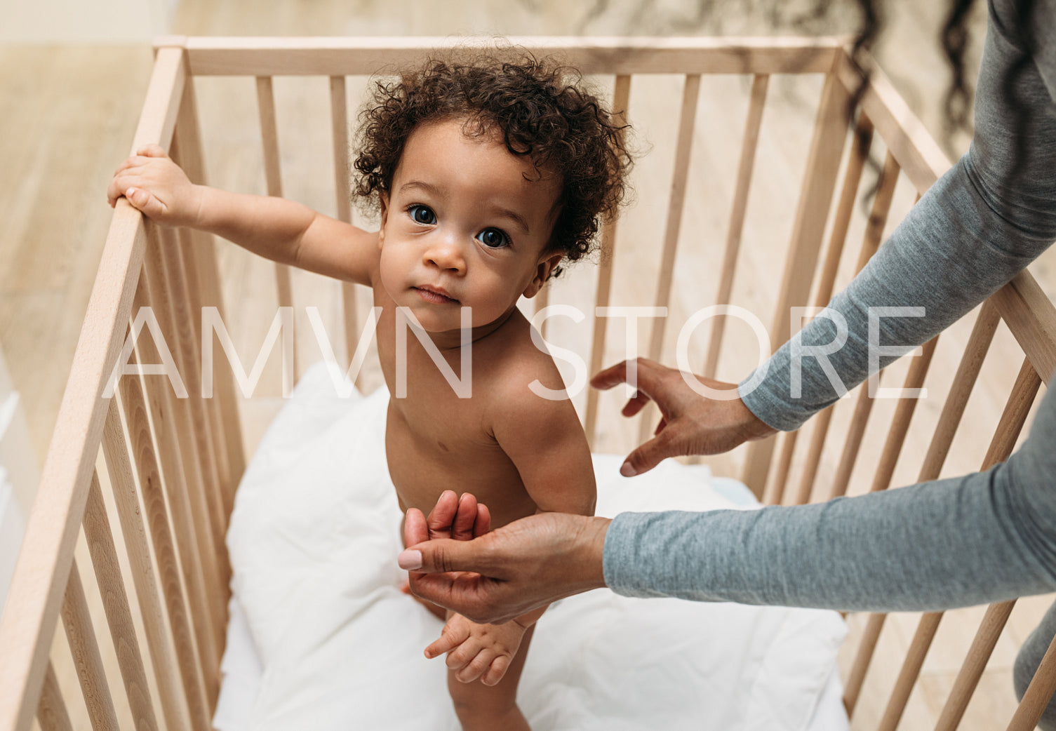 Portrait of baby boy standing in crib	