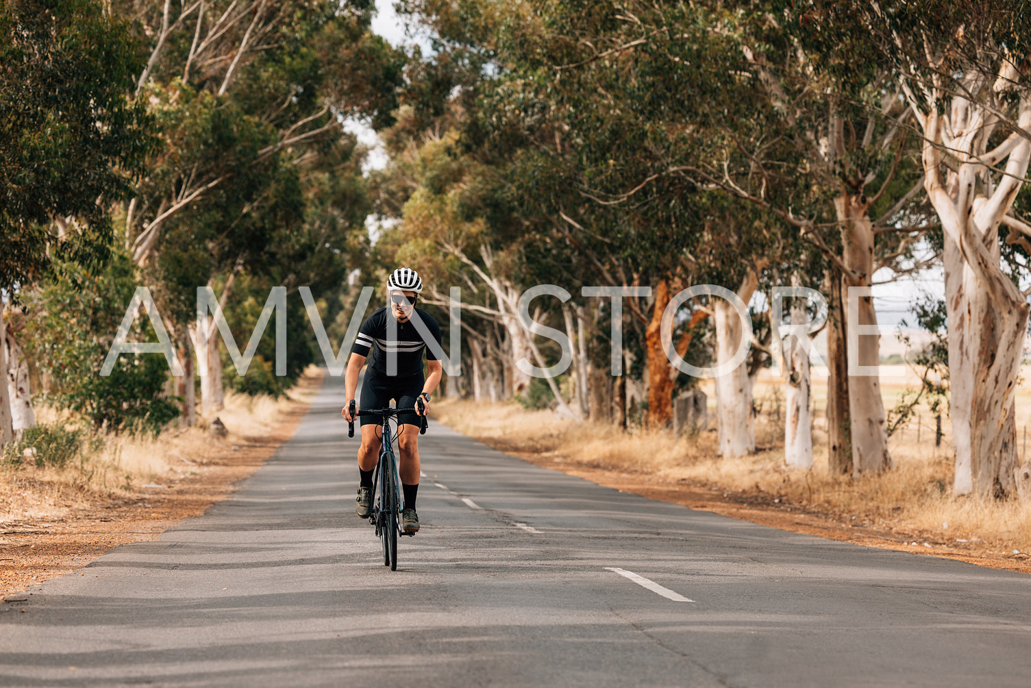 Woman riding bicycle on empty road. Cyclist rides her bike throu