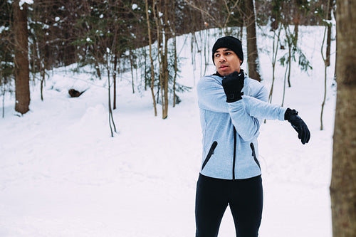 Sportsman warming up his hands. Young athlete in sport clothes preparing for run.