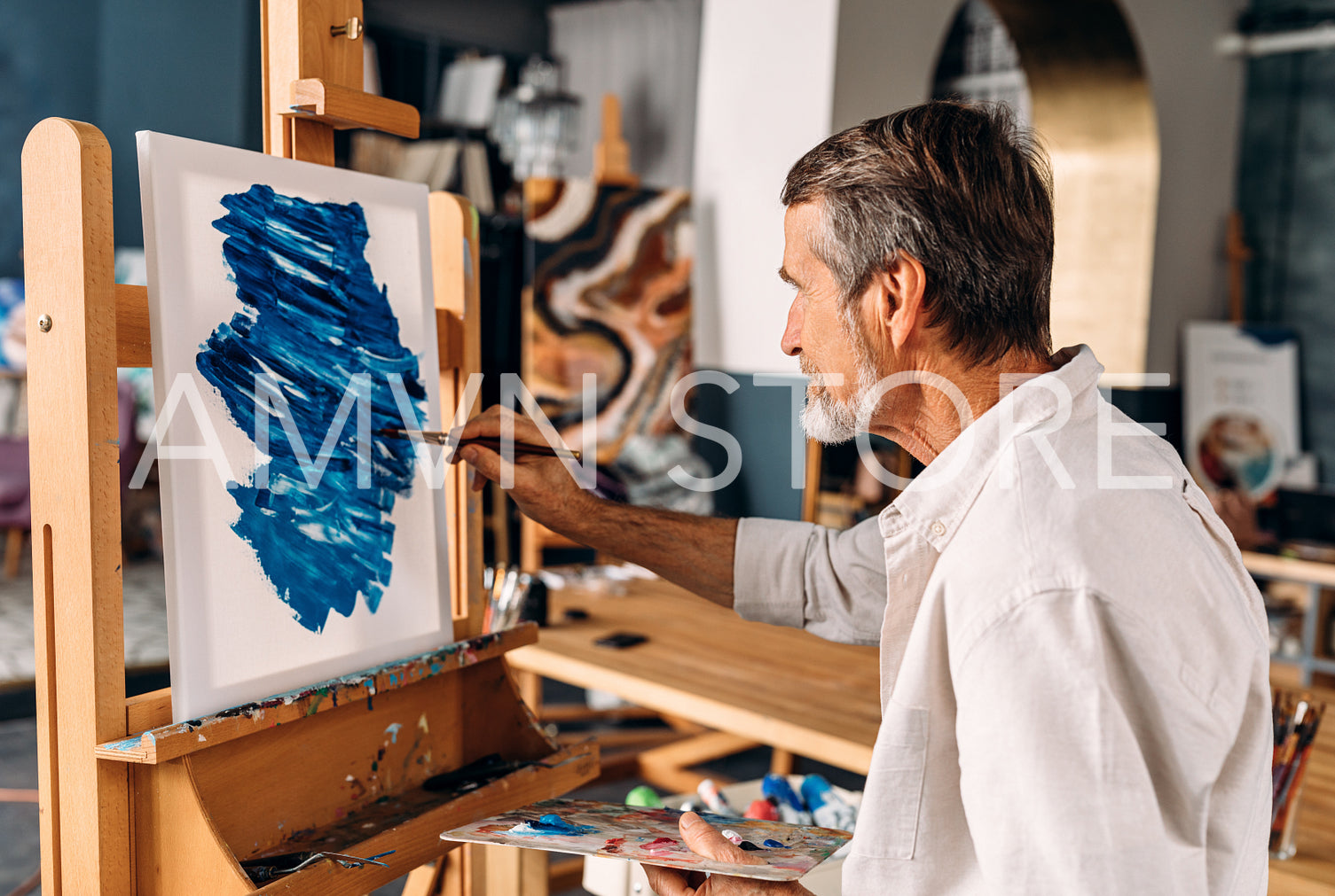 Enthusiastic artist working in his studio drawing on canvas	