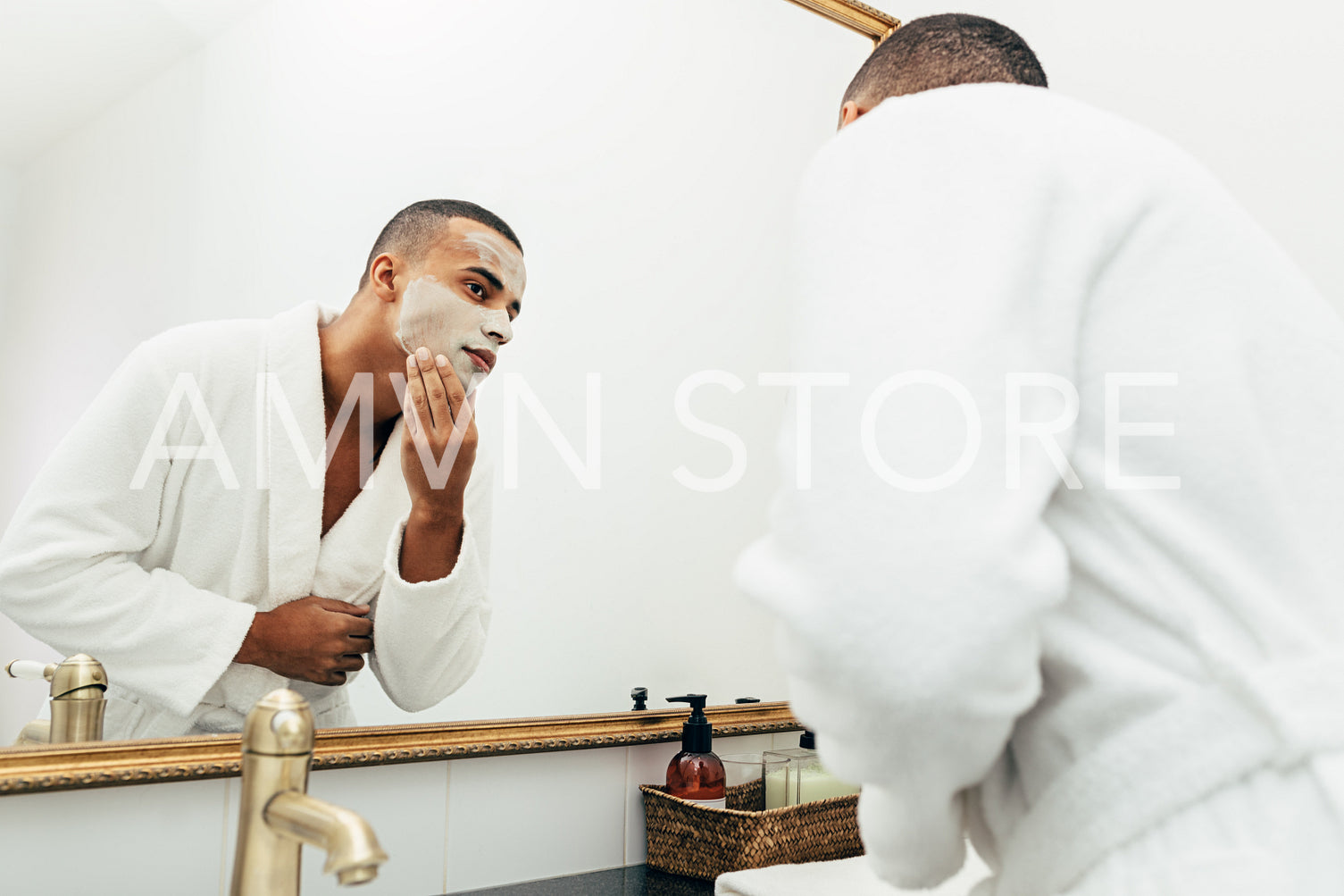 Man looking in the mirror with white clay mask on his face	