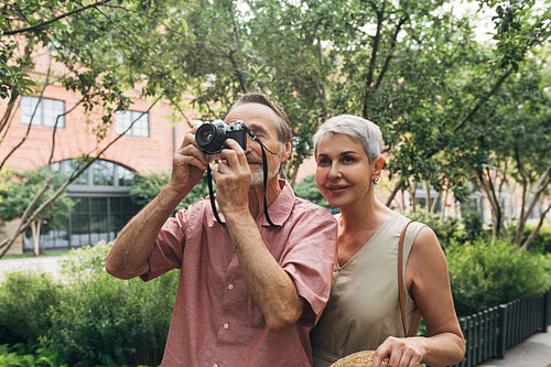 Senior couple stopped during a walk to take a picture of something