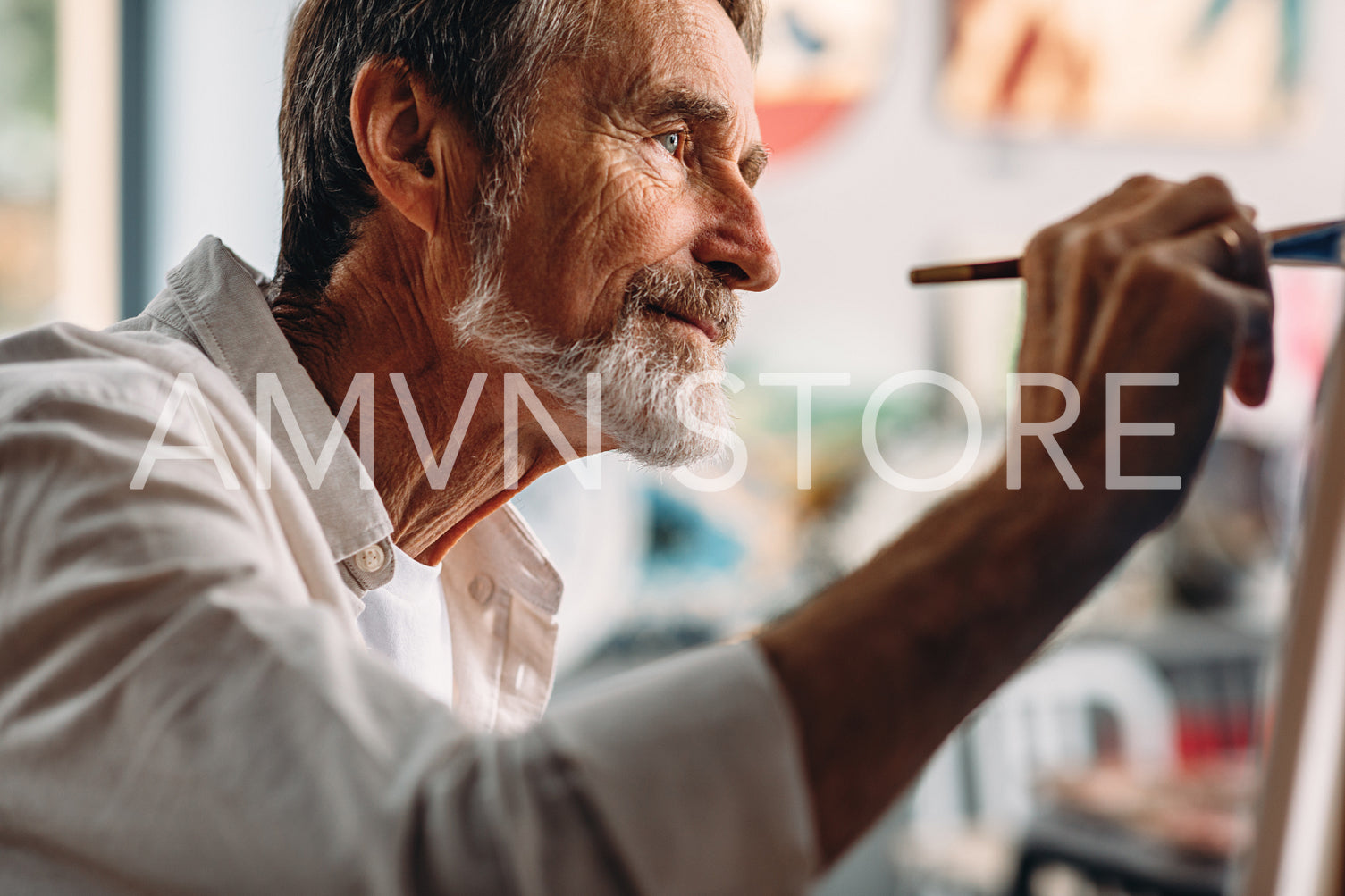 Close up portrait of senior painter drawing on canvas in studio	