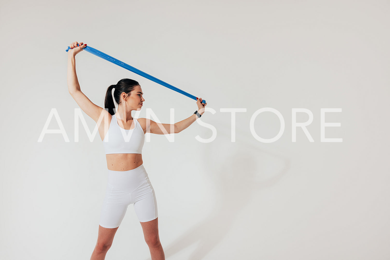 Slim woman in white fitness attire warming up hands on white background