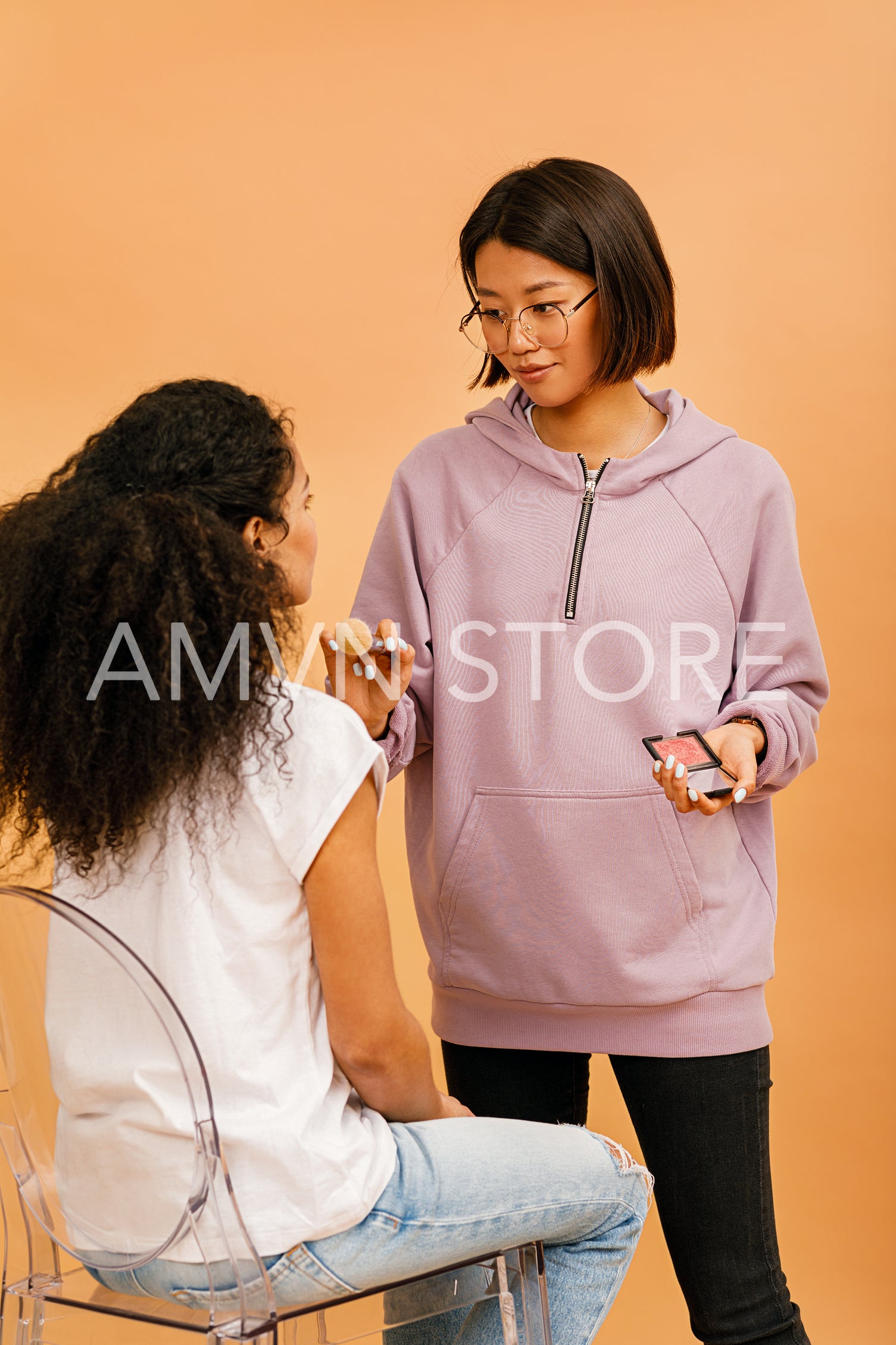 Young make up artist working with model in studio	