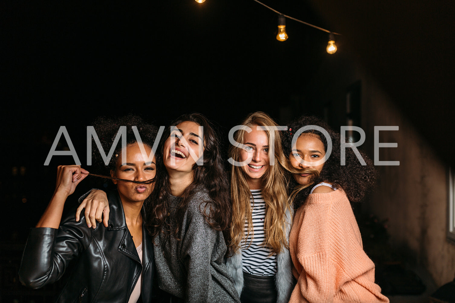 Shot of female friends having fun at night, looking at camera	