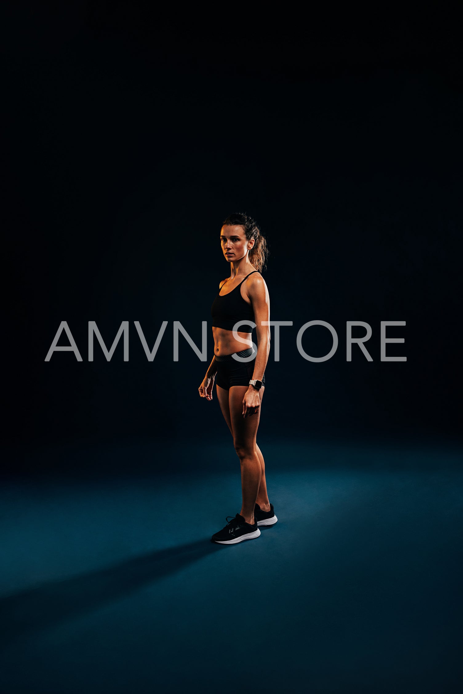 Portrait of young woman in sportswear relaxing on black background during training