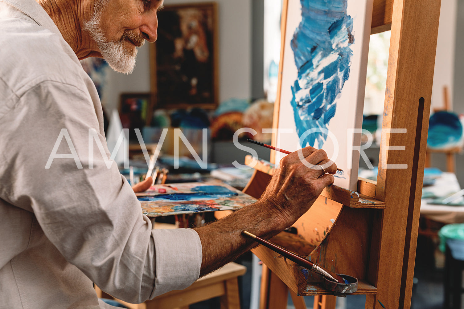 Close up of a senior artist drawing on canvas in studio	