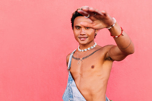 Young man with bare chest smiling and looking at camera