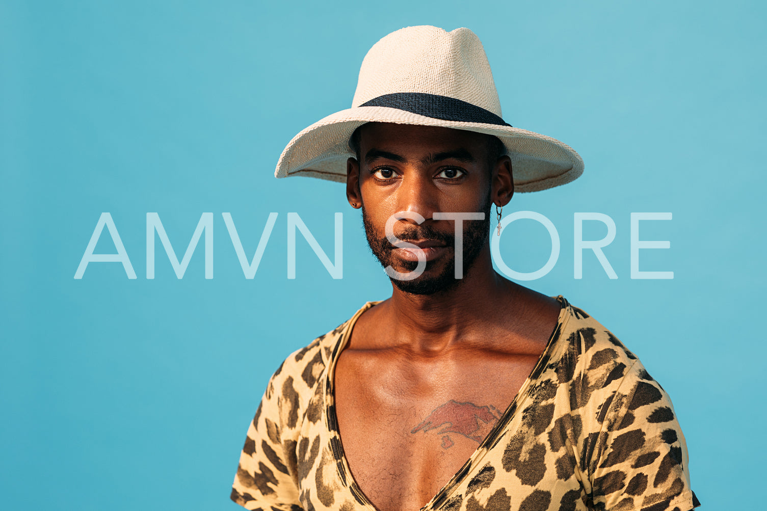 Portrait of African American guy wearing straw hat and looking straight of a camera