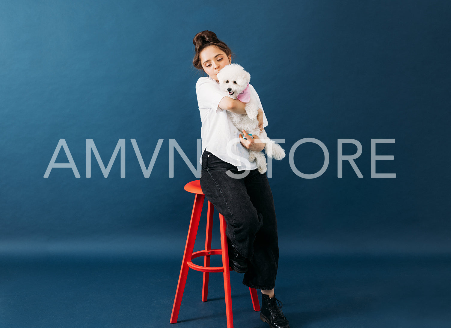 Woman in casuals sitting on chair in studio with her little fluf