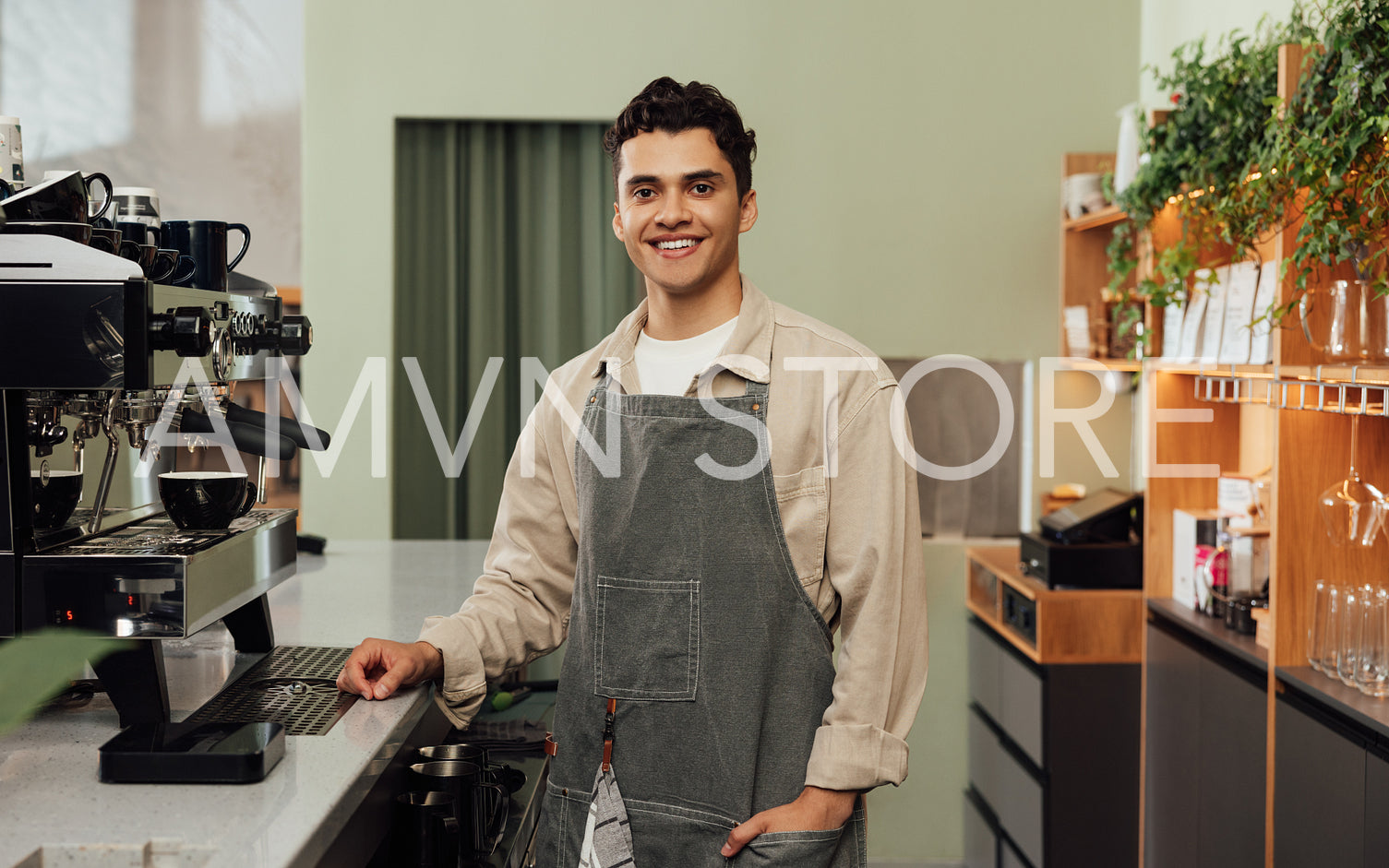 Smiling male barista in a cafe. Portrait of a cheerful man in an apron working as a barista.