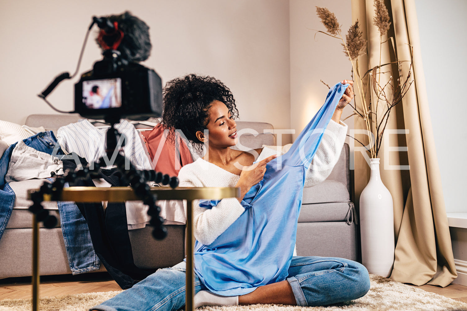 Fashion vlogger recoding video about casual shirt in living room	