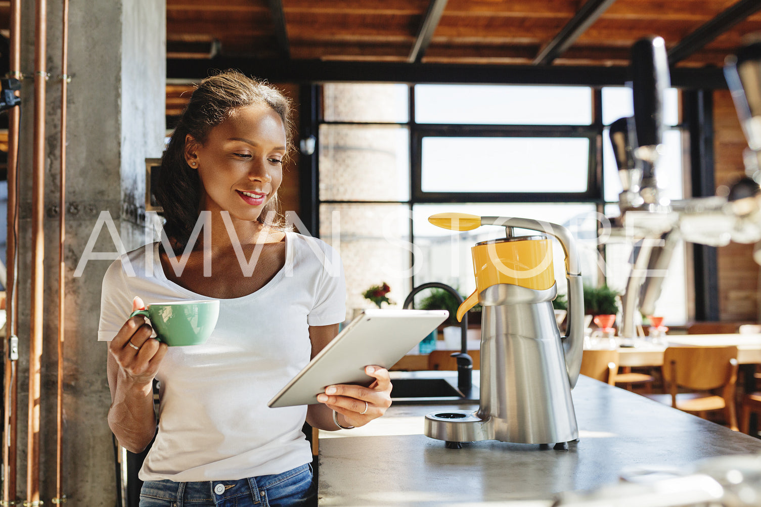 Young business owner standing at counter. Woman reading from digital tablet in her cafe at morning.	