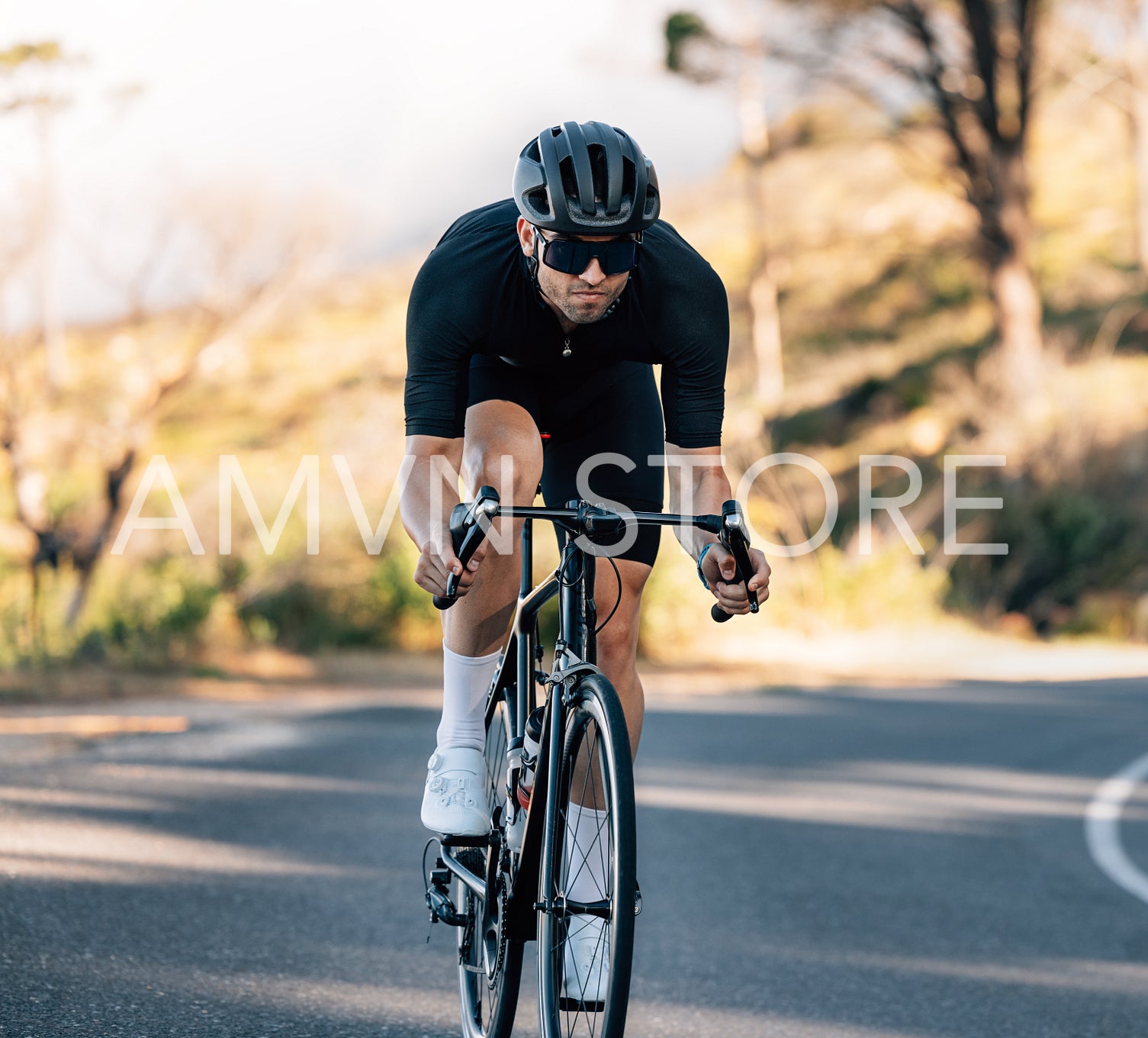 Sportsman in fitness attire on a road bike. Young male in goggles and a helmet riding a bicycle.