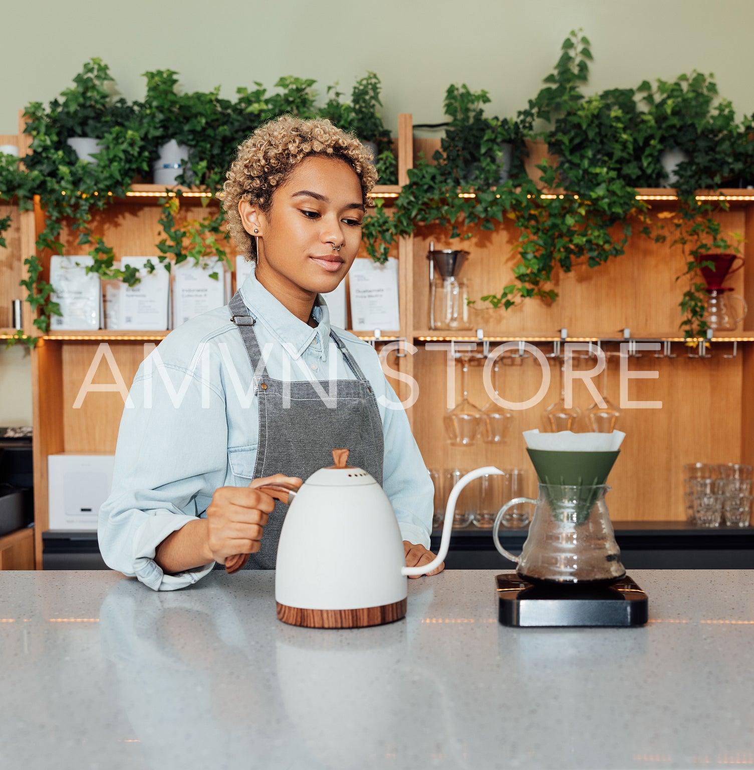 Female barista at the counter with a kettle. Young woman making coffee with a filter.