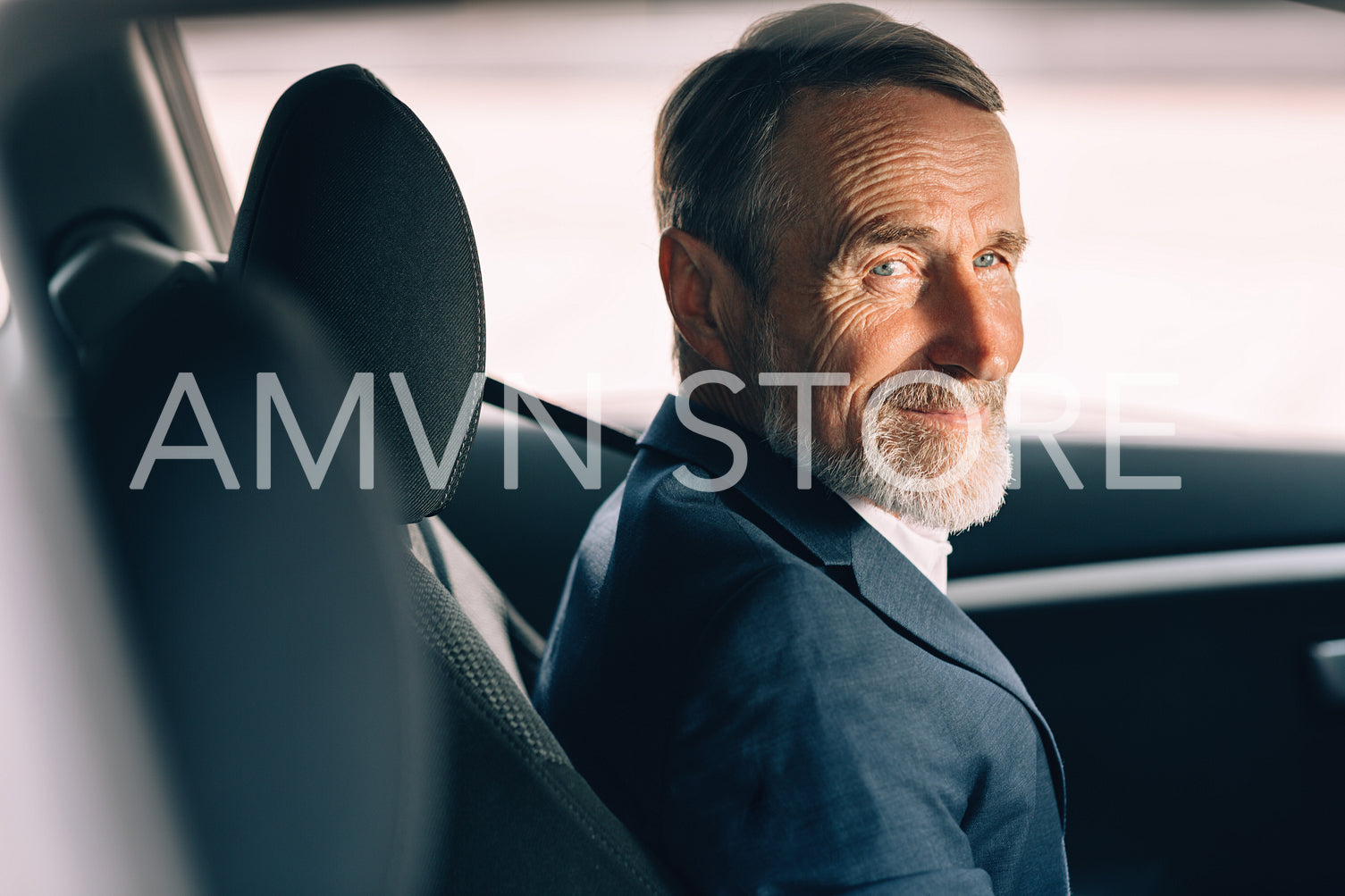 Side view of a senior driver looking away. Man in formal wear sitting inside a car.	