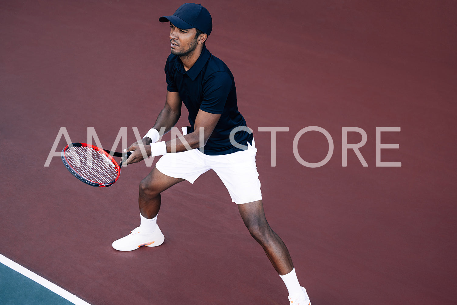 Young tennis player standing on the tennis court baseline ready to return the serve 