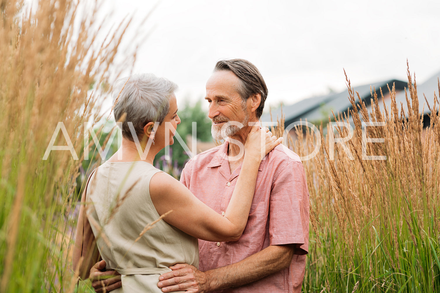 Mature couple hugging each other while standing on a wheat field