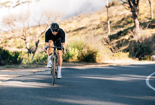 Professional cyclist on his road bike. Male cyclist exercising on an empty road.