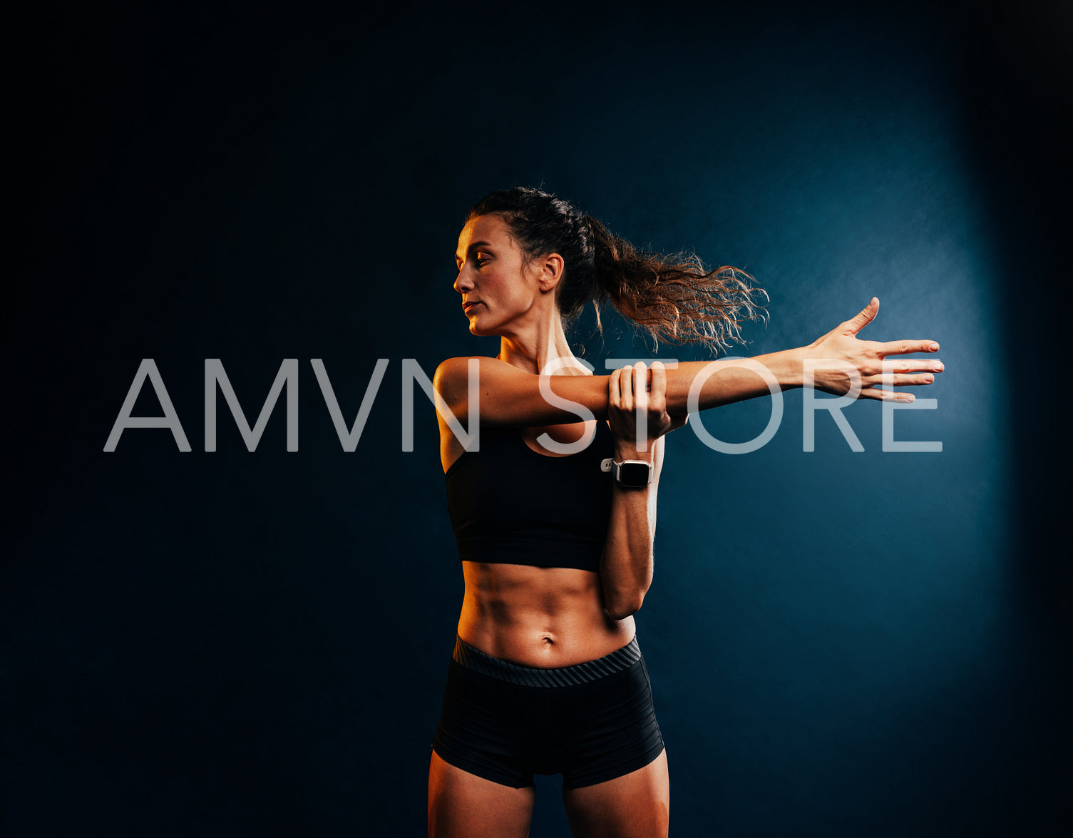 Muscular woman doing intense training warming up her hands on black background