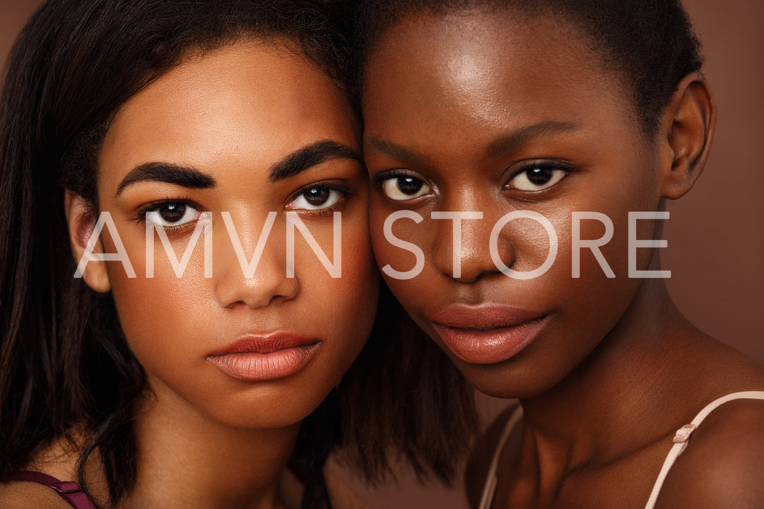 Close up portrait of two beautiful African American women looking at camera in studio	