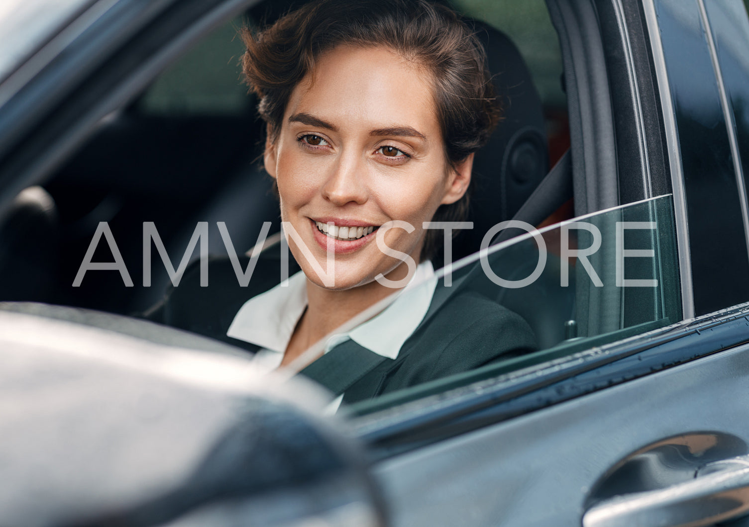 Smiling businesswoman in a car. Young female in formal wear driving a car.	