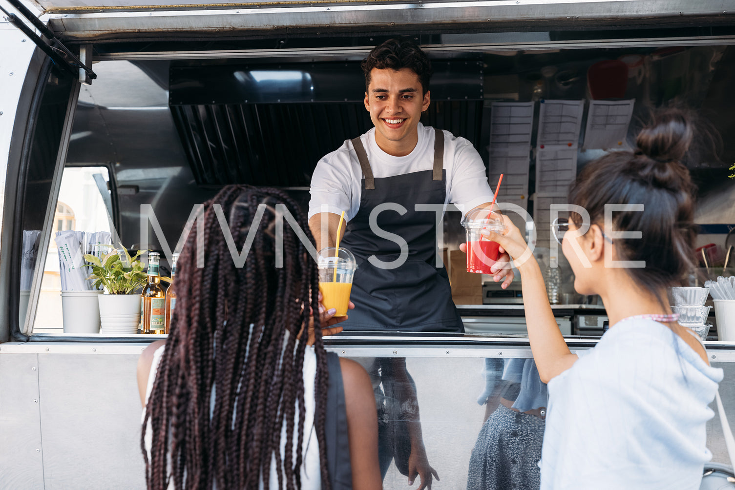 Back view of two females buying drinks