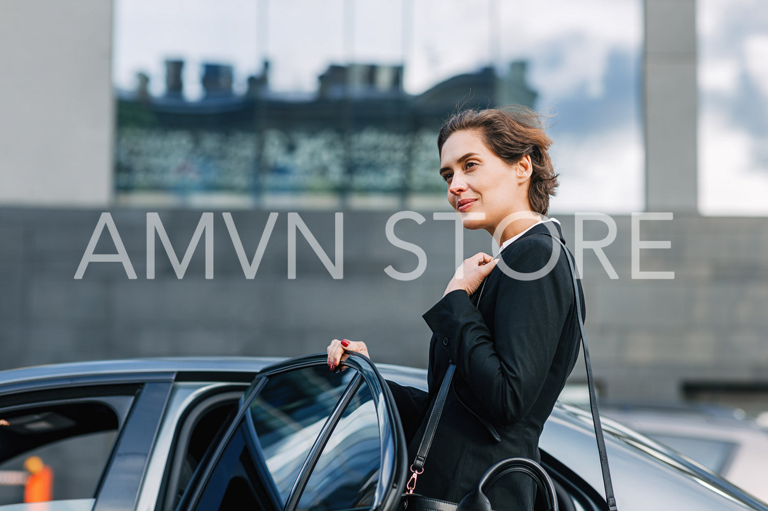 Businesswoman opening a door and entering a taxi	