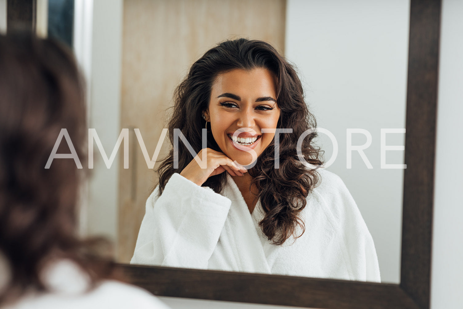 Reflection of happy woman in the mirror wearing white bathrobe	